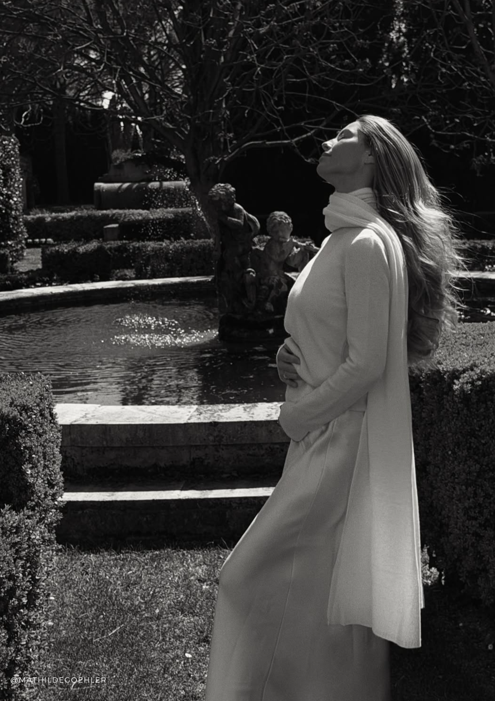 Woman wearing a white cashmere sweater with an extra-long cashmere scarf and a flowing white silk maxi skirt — Aspen sweater, Chamonix scarf and Alisa silk skirt by SERENITY.