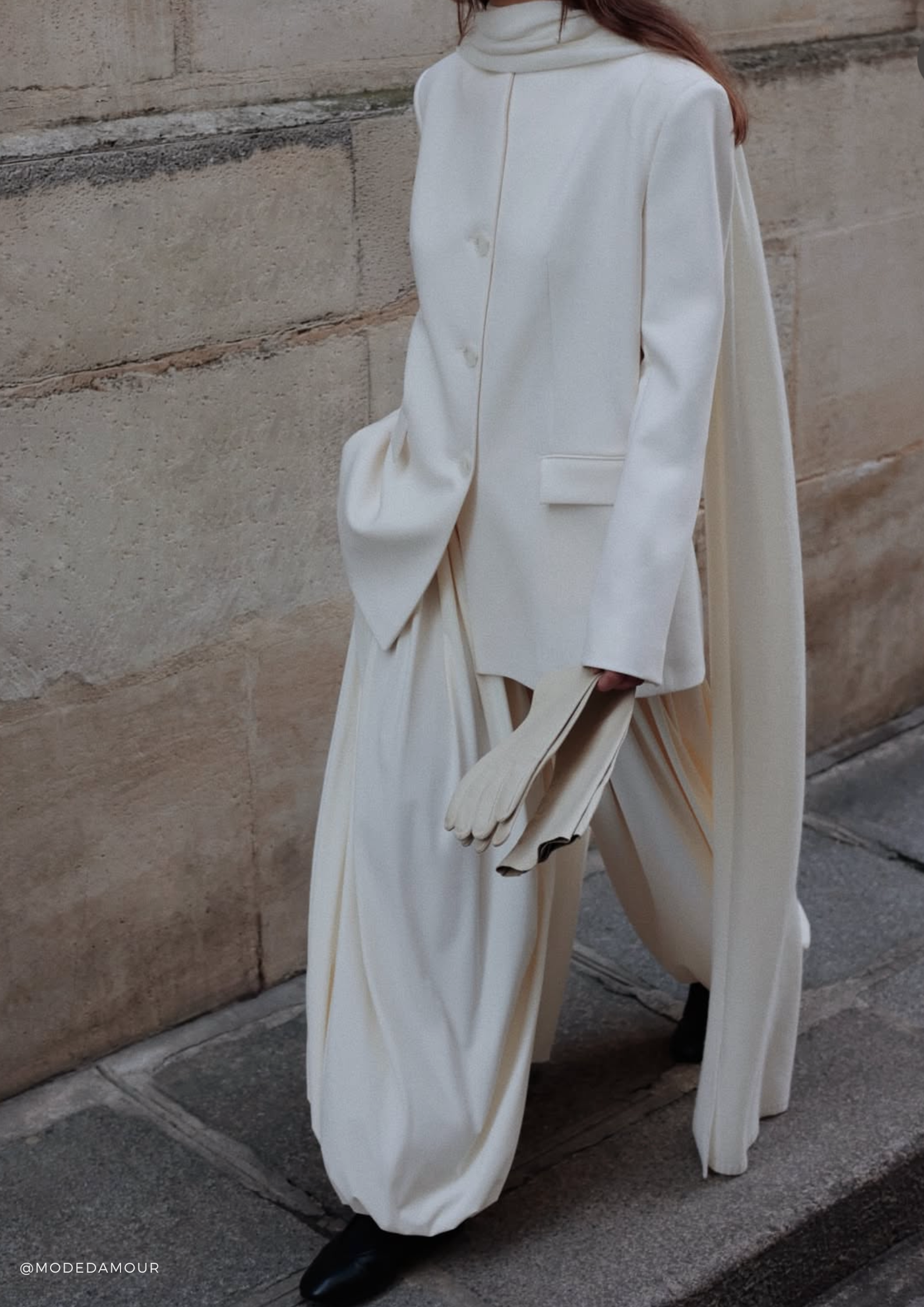 Woman styling the SERENITY Chamonix long white cashmere scarf with a white blazer and flowing wide-leg trousers.